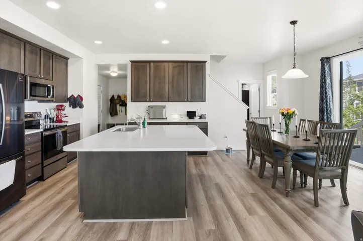 Open-concept kitchen and dining area featuring wood-finish flooring