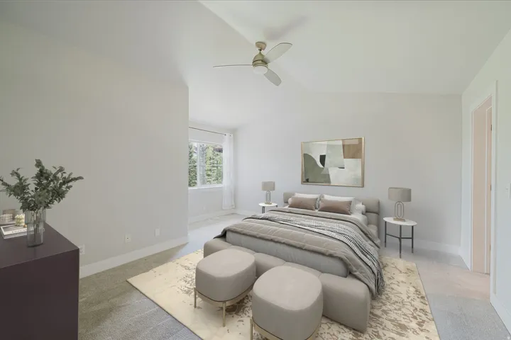 Carpeted bedroom featuring a ceiling fan, a window with exterior tree views, and white baseboards - Virtually staged