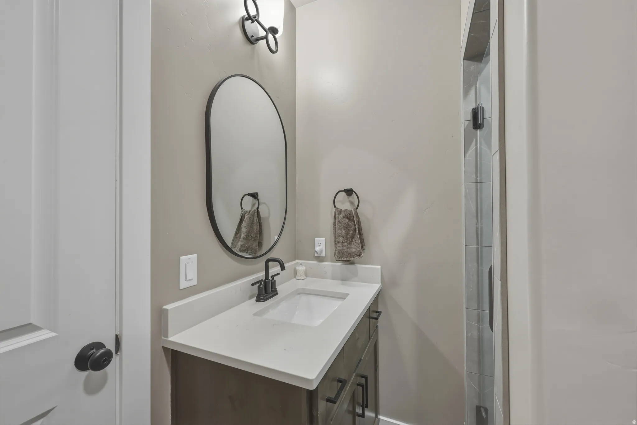 Contemporary bathroom featuring a dark wood-finish vanity with a light-toned countertop and an integrated sink