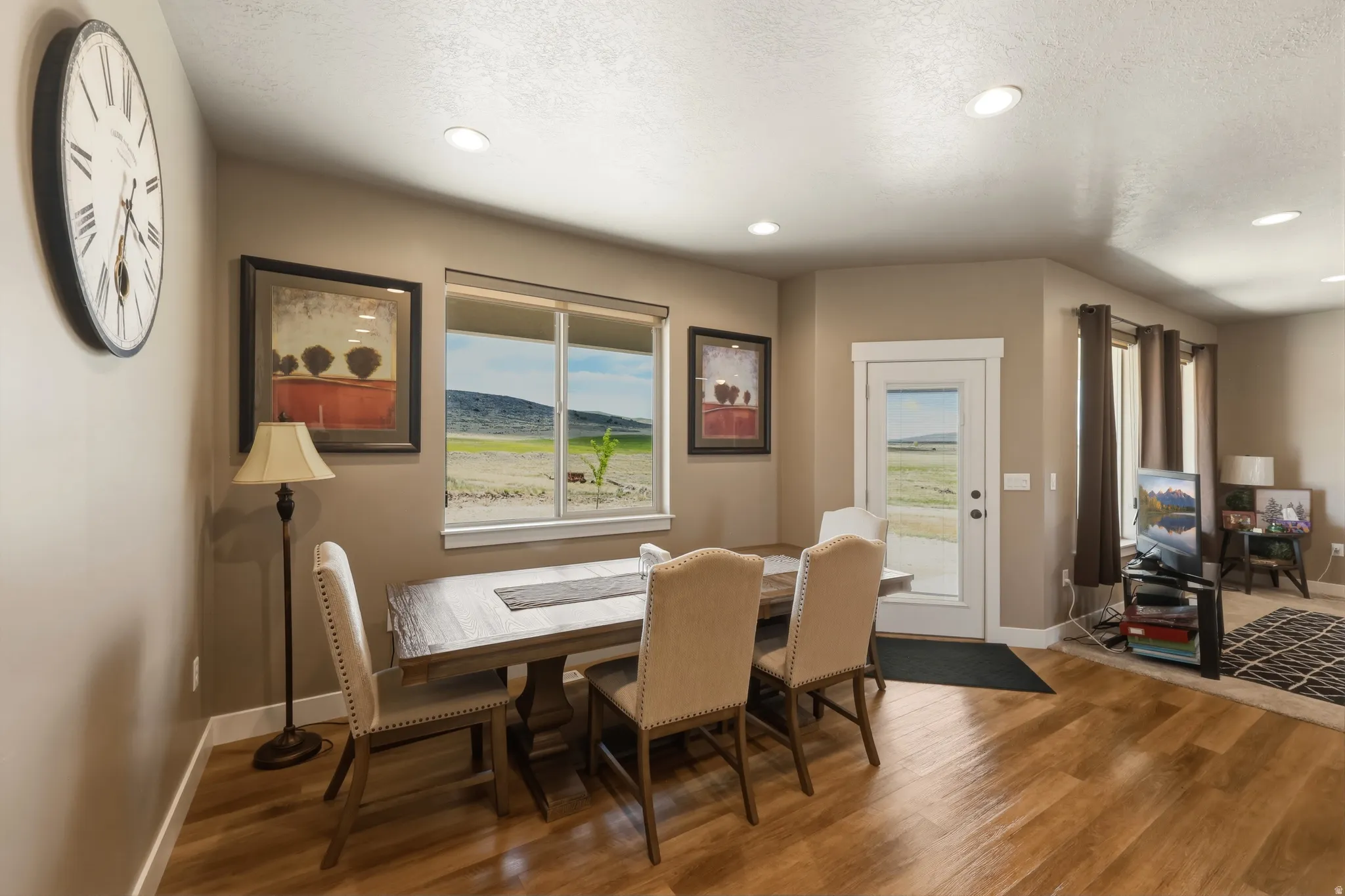 Dining area featuring wood-finish flooring, recessed lighting, and a white-framed window