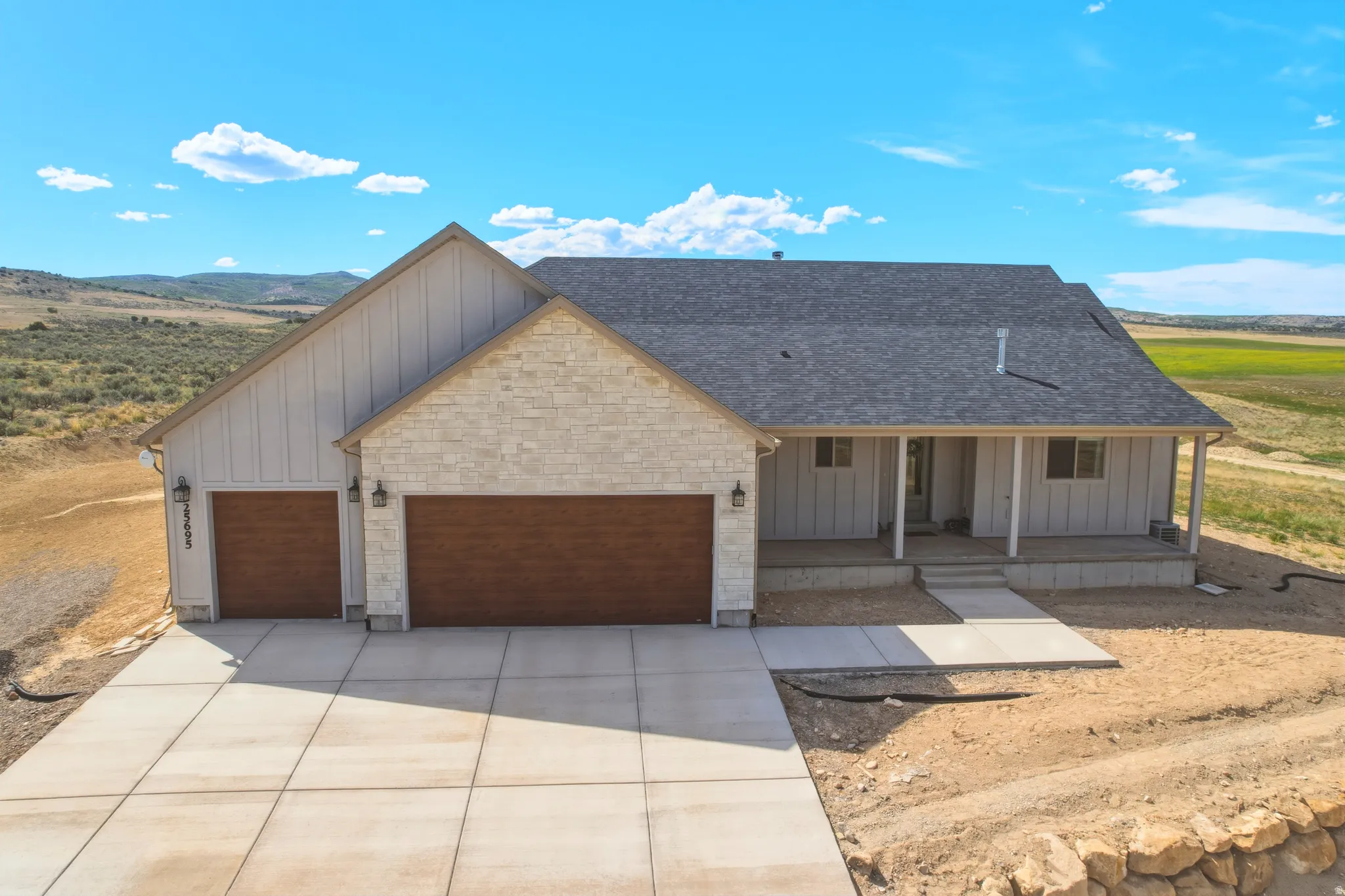 Contemporary farmhouse exterior featuring board and batten siding and light-colored stone accents