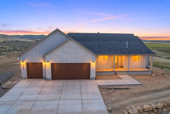Contemporary exterior featuring stone veneer, vertical siding, and a dark shingle roof