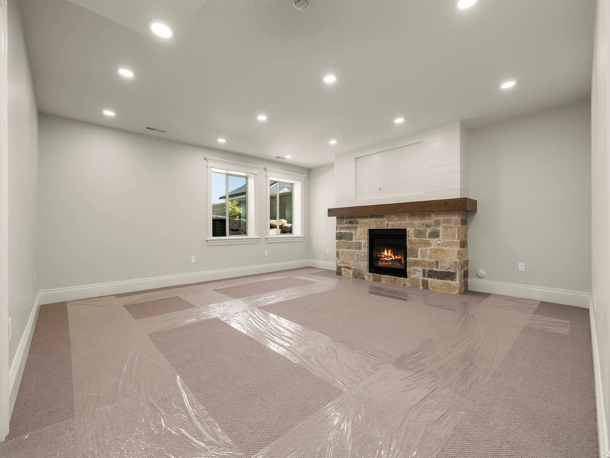 Stone-faced fireplace with a wood mantel and shiplap detailing