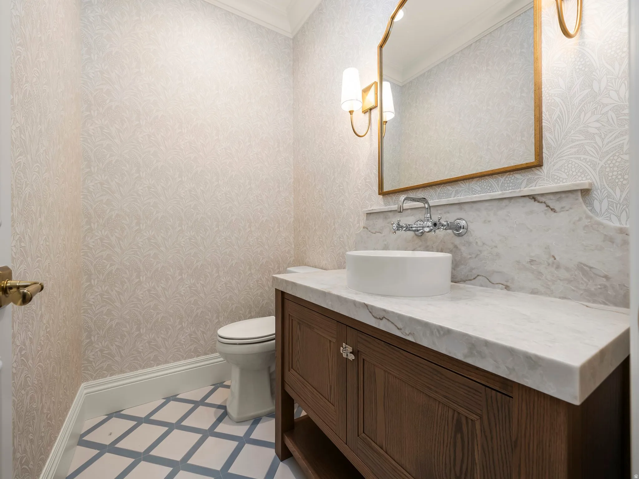Powder room featuring a wood-finish vanity with a vessel sink, a wall-mounted faucet, and a stone countertop