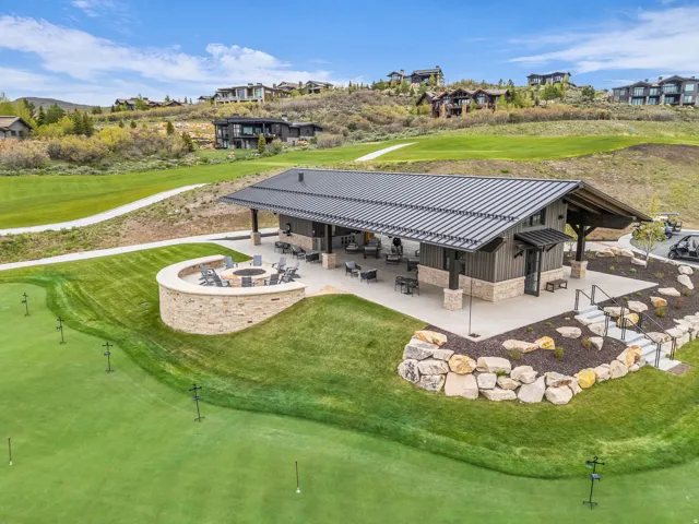 Covered outdoor patio with a metal roof, stone accents, and integrated lighting