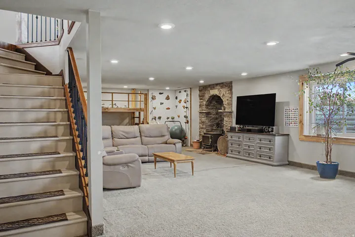 Spacious lower-level living area with carpet flooring and recessed lighting