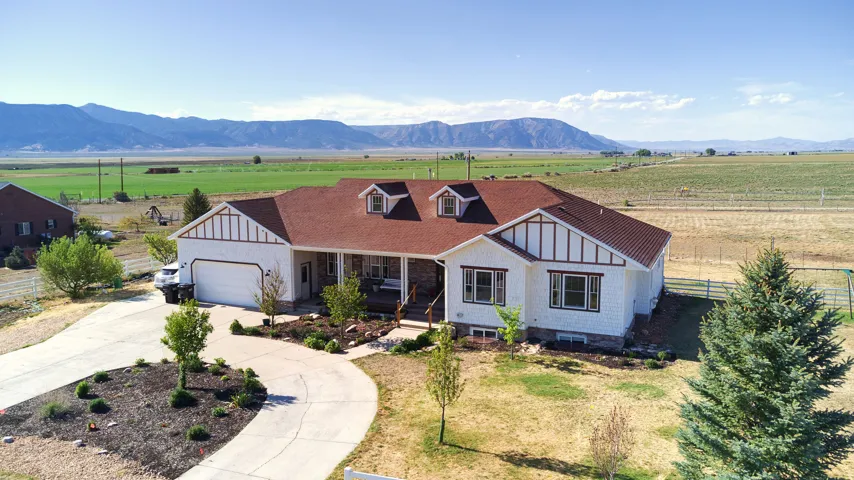 Ranch-style residence featuring a red-brown roof, white siding, and stone accents