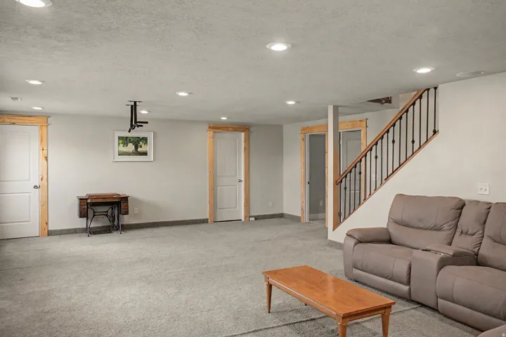 Spacious interior room featuring light gray carpeting and recessed lighting