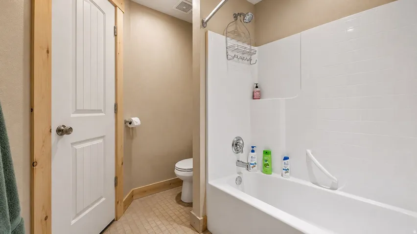 Bathroom featuring a white tub/shower combination with a single-handle faucet and showerhead