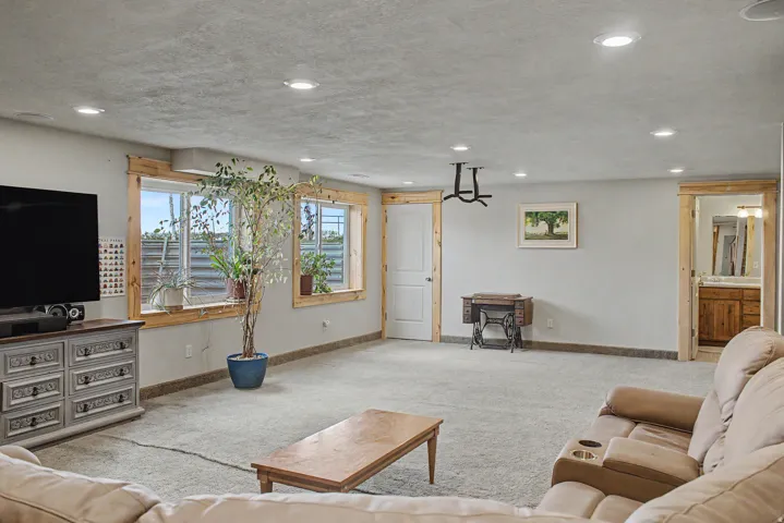 Spacious room featuring light gray walls, light-colored carpeting, and recessed ceiling lighting