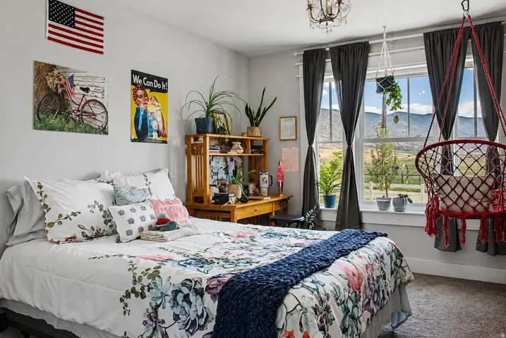 Spacious room featuring multiple windows with mountain scenery, a decorative chandelier, and light gray wall paint