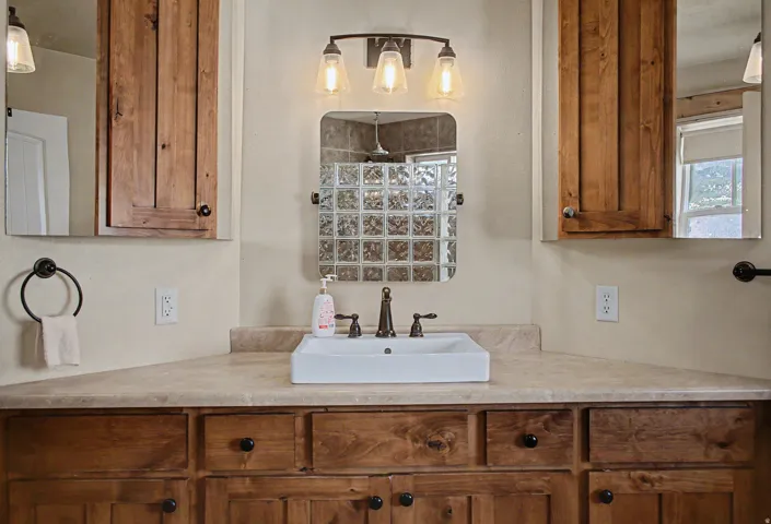 Bathroom vanity featuring a rectangular vessel sink, bronze-finish faucet, and a light-toned countertop