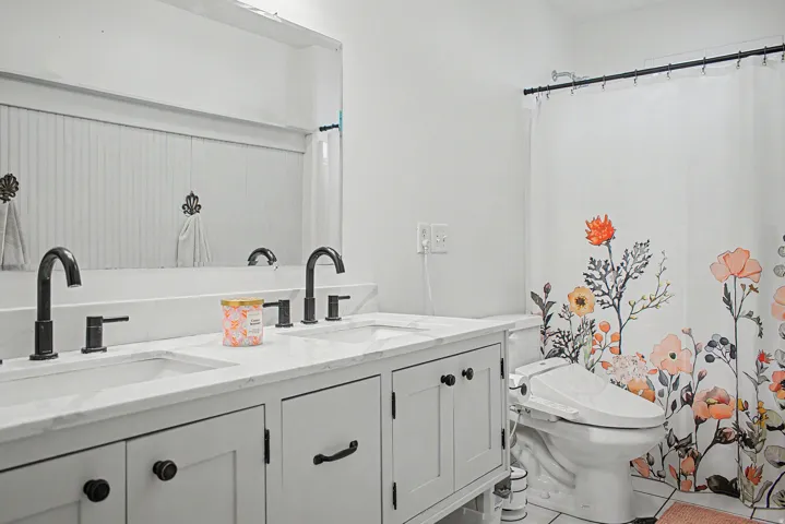 Dual vanity with white countertop, undermount sinks, and matte black faucets
