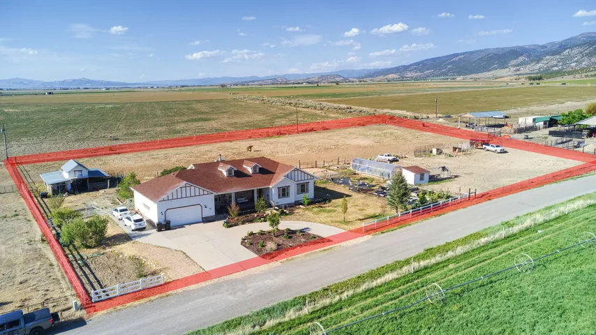 Spacious property featuring a single-story residence with an attached garage, a paved driveway, and established landscaping