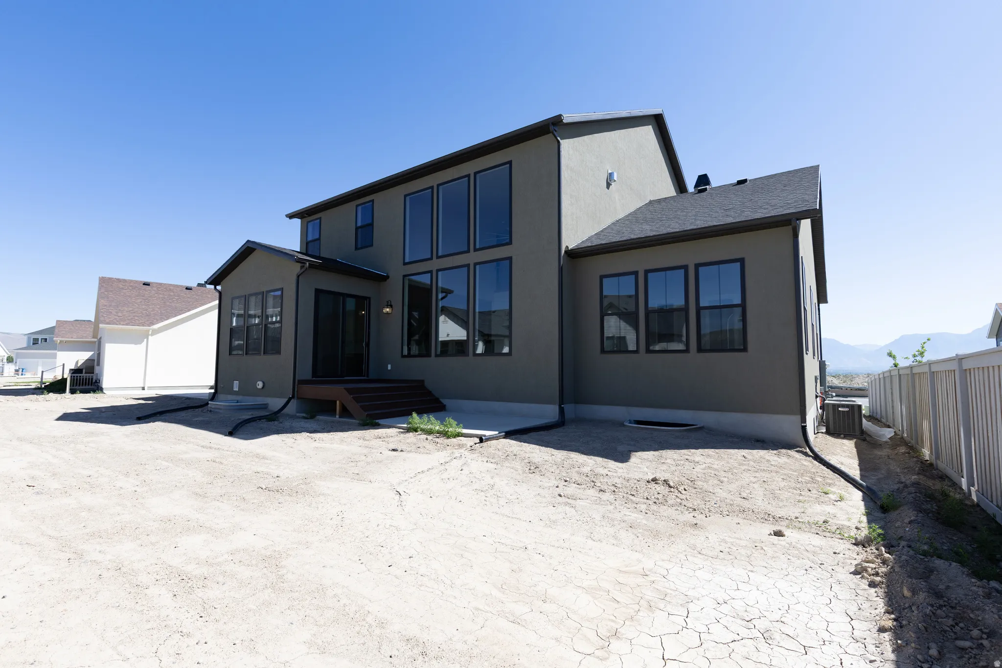 Contemporary two-story exterior with stucco finish and dark trim windows