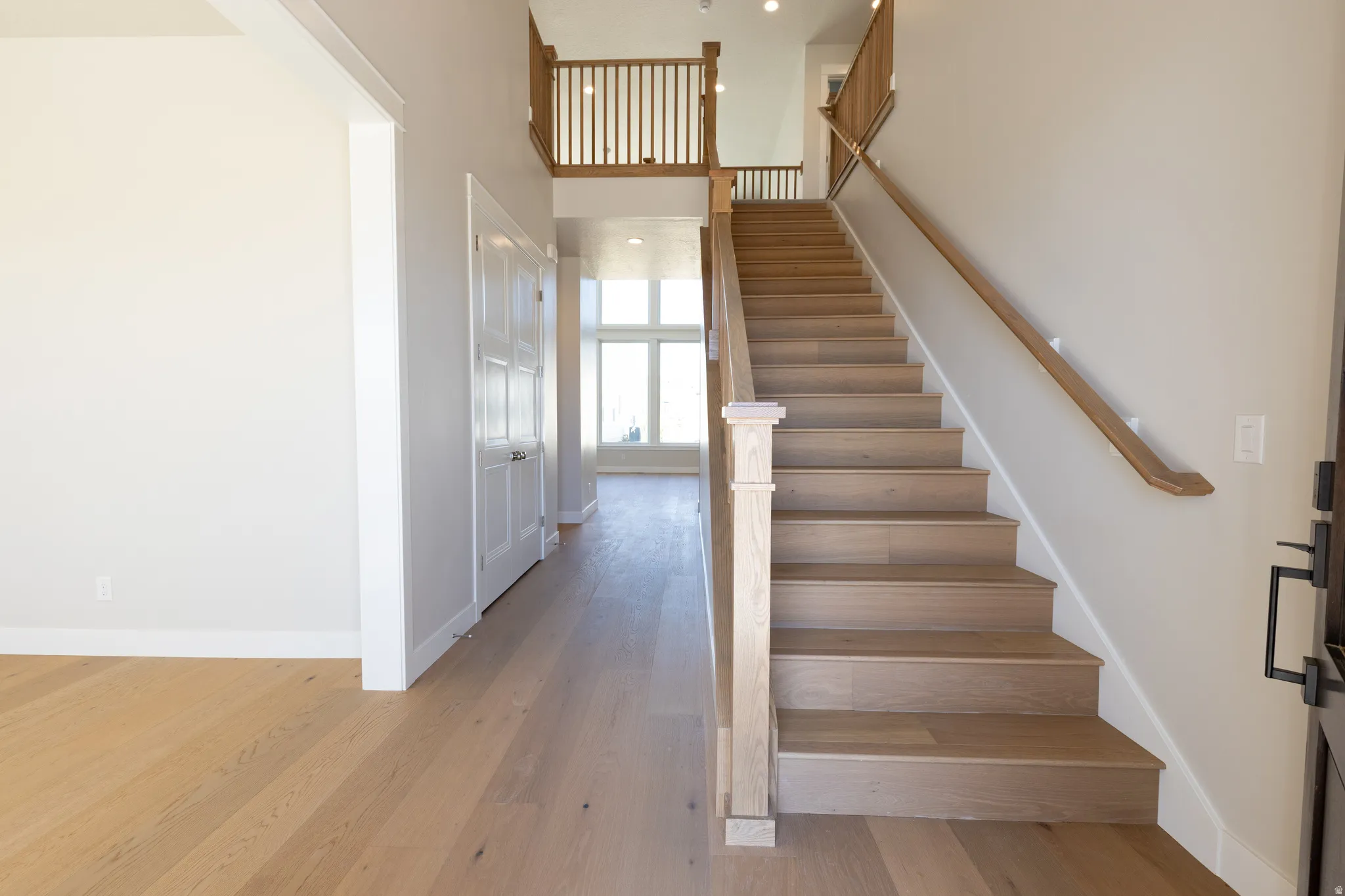 Entryway featuring a grand staircase with wood-finish treads and railing