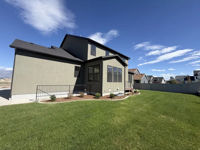 Expansive green lawn with a privacy fence