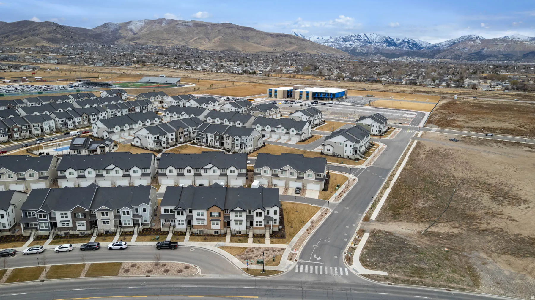 Newly constructed residential community featuring multi-story townhomes with attached garages and paved roadways