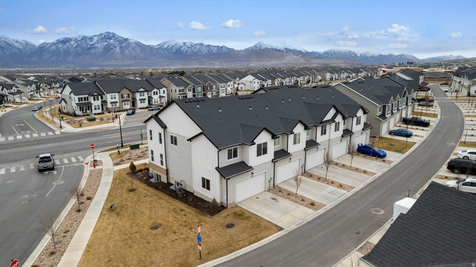 Contemporary townhome community featuring a uniform aesthetic with white siding and dark roofing