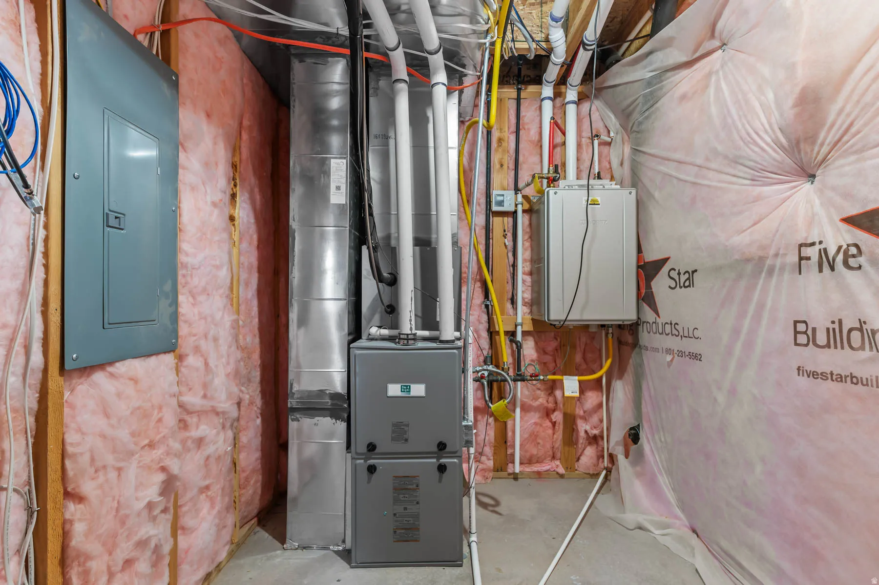 Utility area featuring a furnace system, water heater, electrical panel, exposed ductwork, and insulation