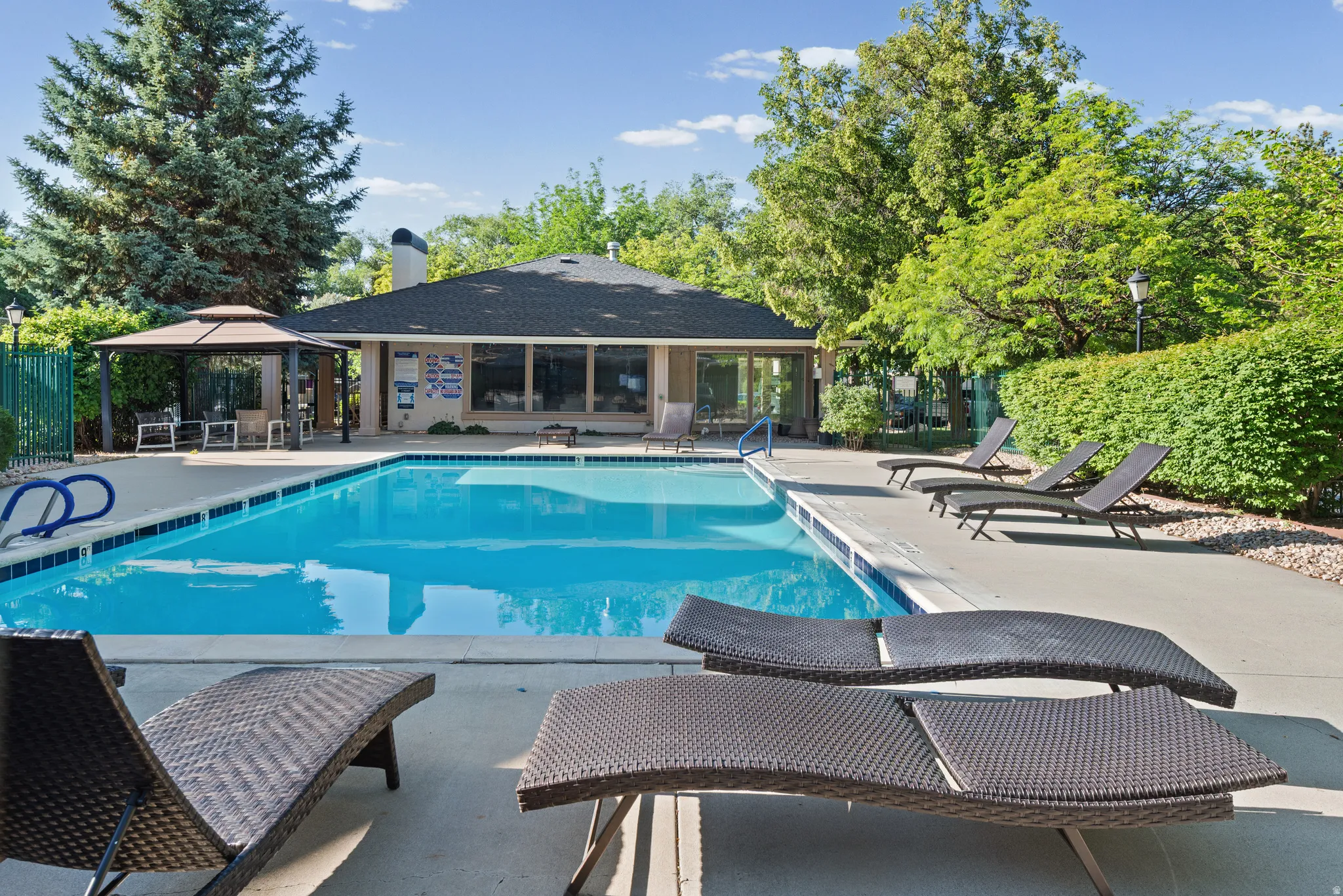 Outdoor swimming pool featuring a concrete deck and blue tile coping