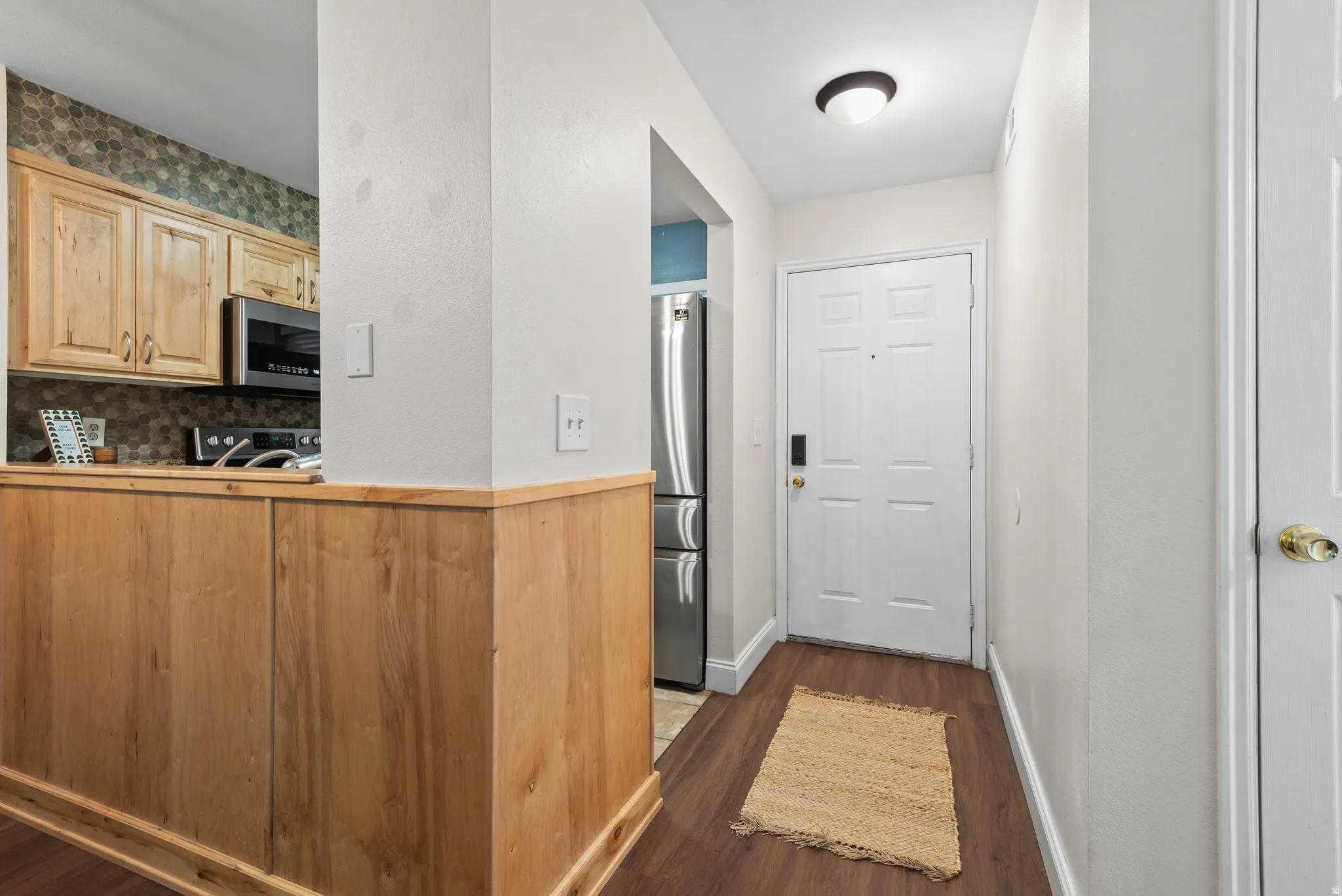 Entryway featuring wood-finish flooring and a paneled white door