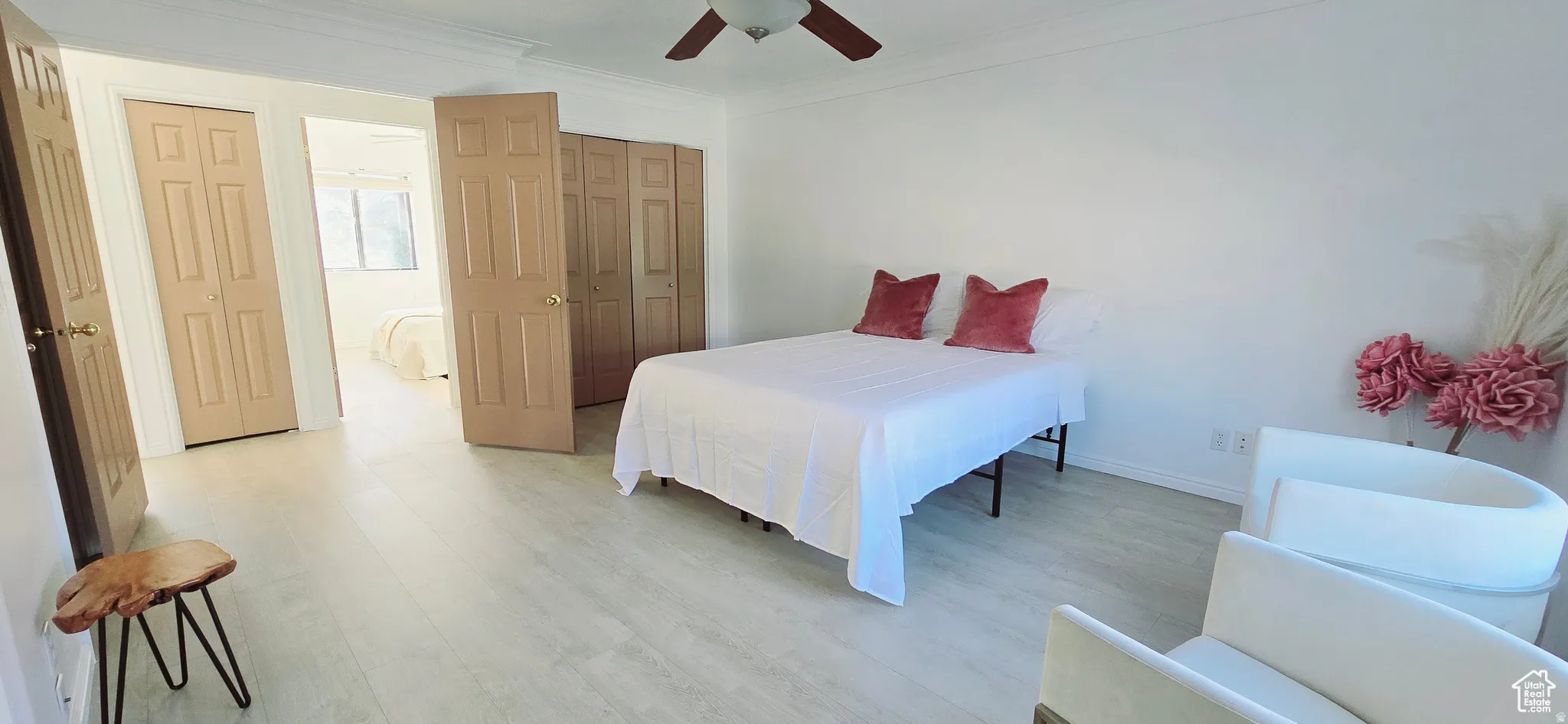 Bright interior space featuring light wood-finish flooring, white walls, and crown molding