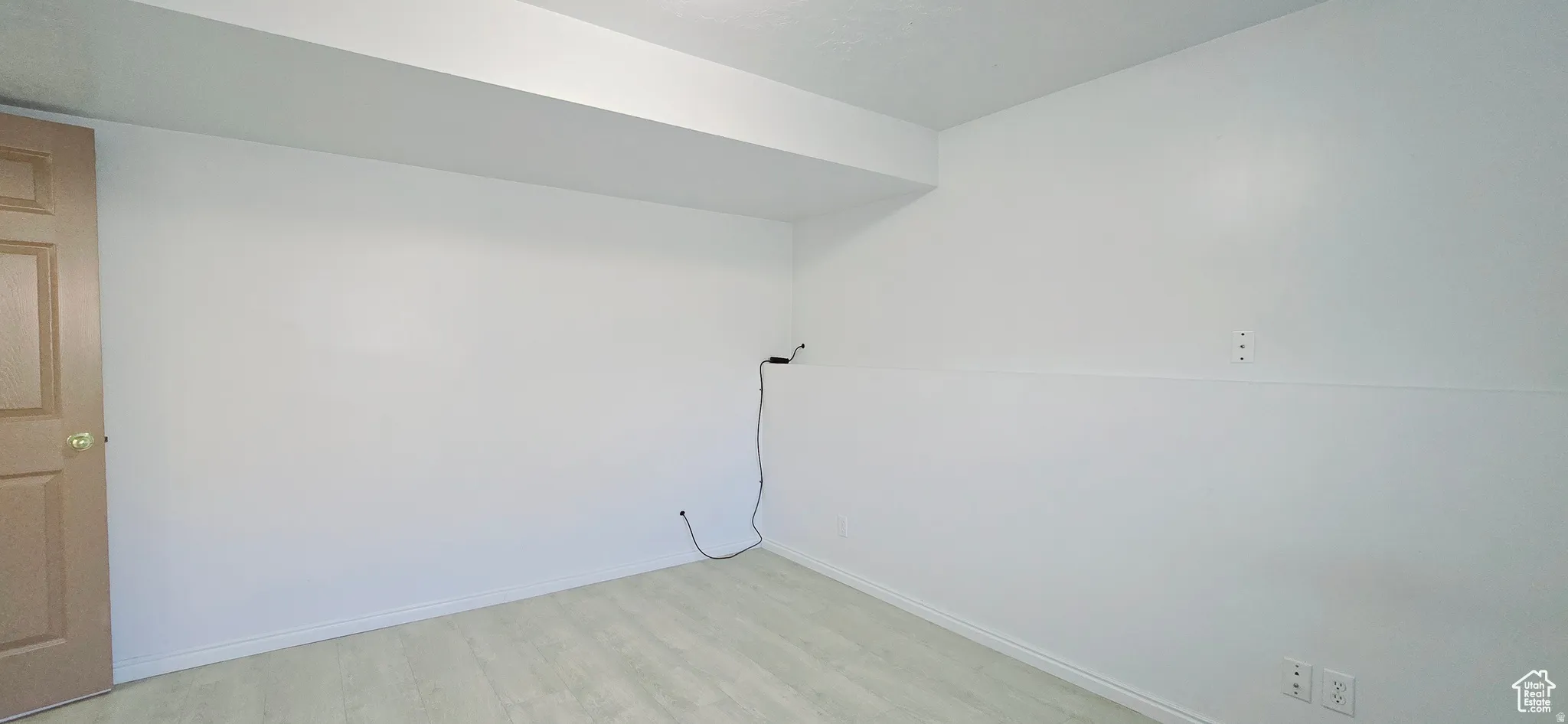 Room featuring white walls, white baseboards, and light wood-finish flooring