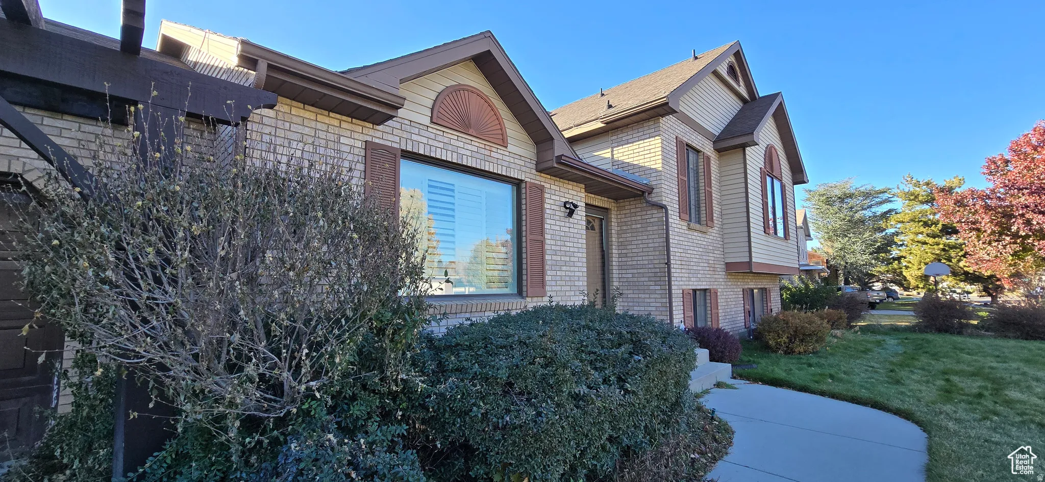 Light brick exterior with contrasting dark brown trim and window shutters