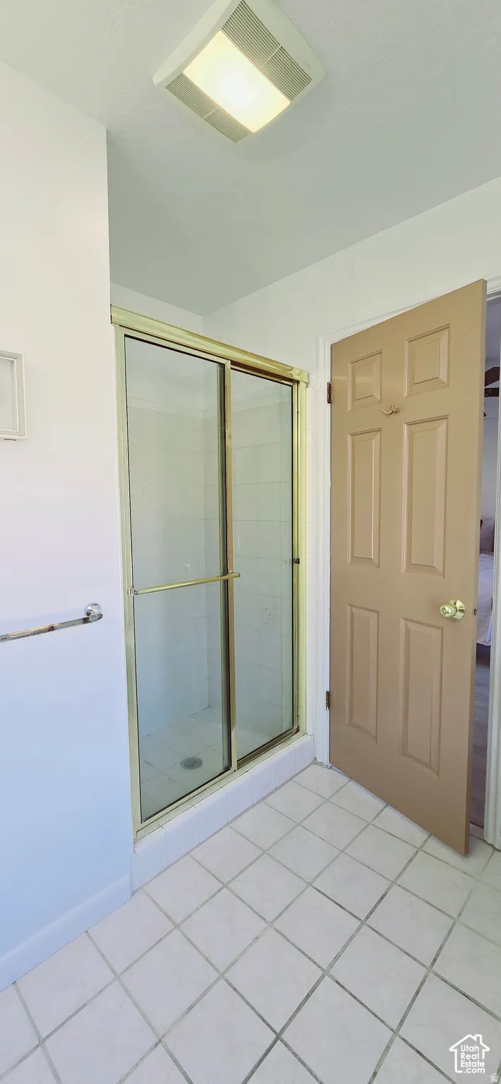 Shower enclosure featuring a framed glass door and a tiled interior