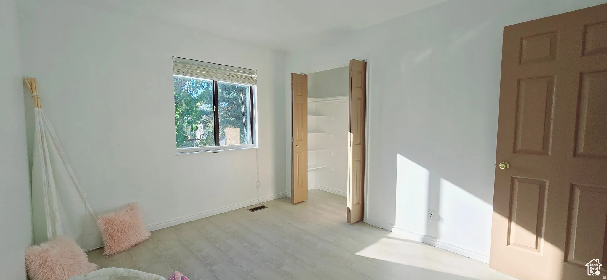 Bright room featuring light wood-finish flooring and white walls