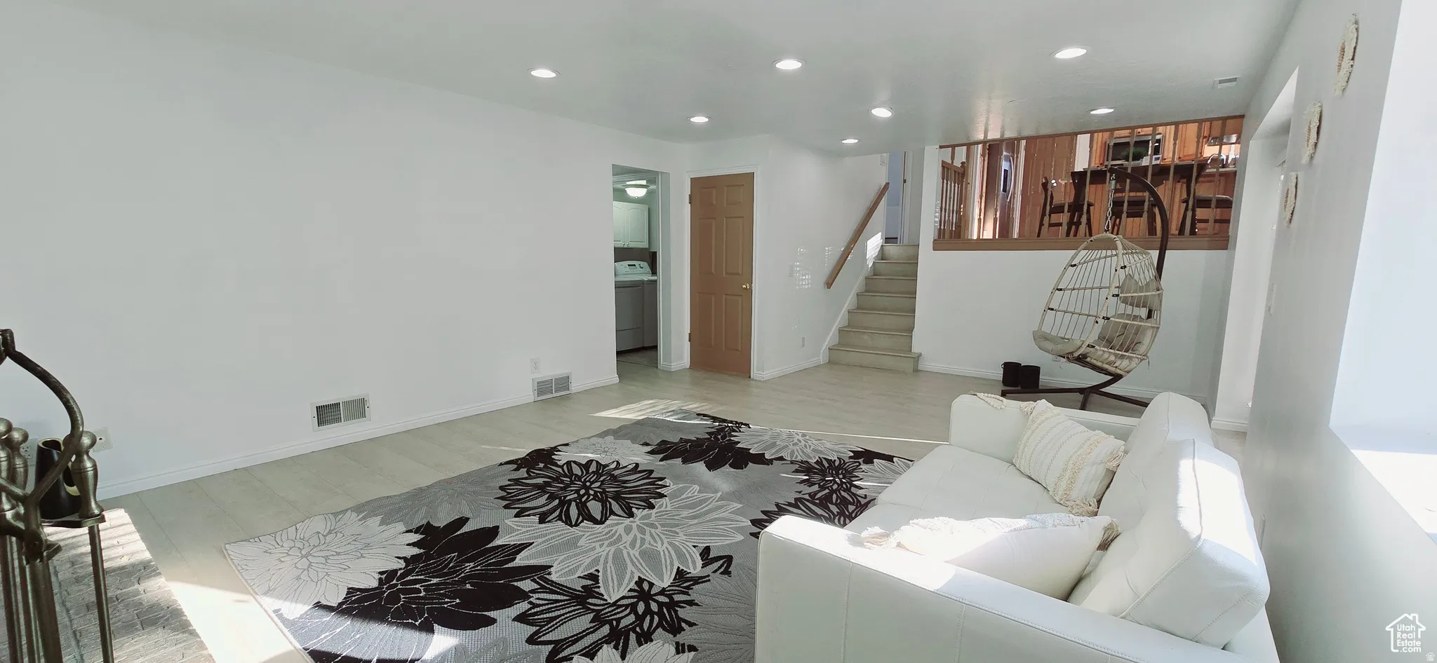 Bright living area featuring wood-finish flooring, recessed lighting, and a white interior paint palette