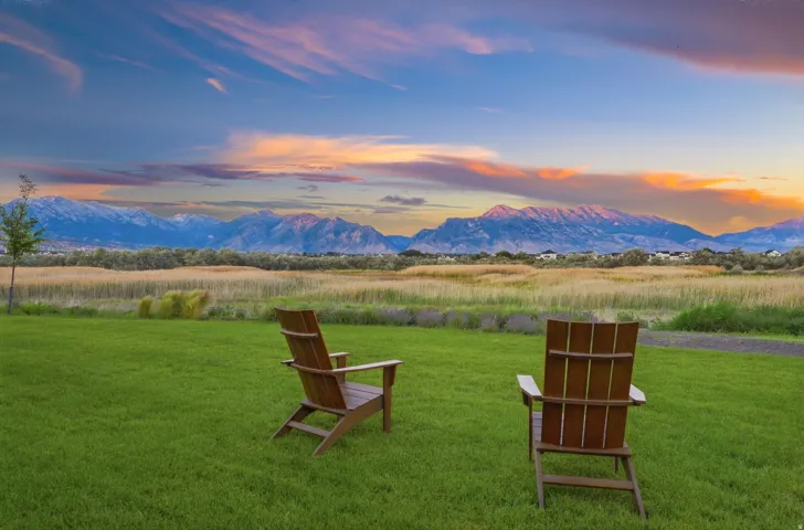 Expansive green lawn with mountain backdrop and natural landscape