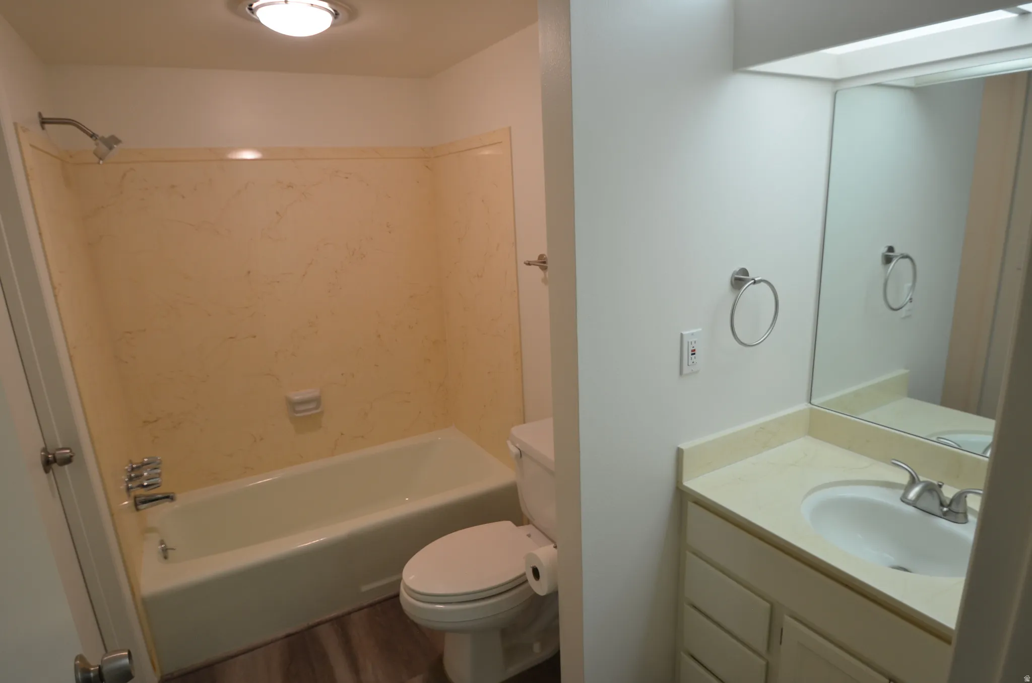 Main bathroom featuring a full vanity with a built-in sink, an integrated mirror, and a bathtub with a shower fixture