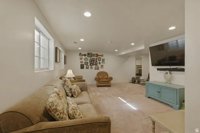 Spacious lower-level area with recessed lighting, light-toned carpeting, and multiple windows