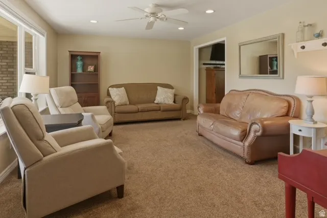 Carpeted living area featuring recessed lighting, a ceiling fan, and light-toned walls