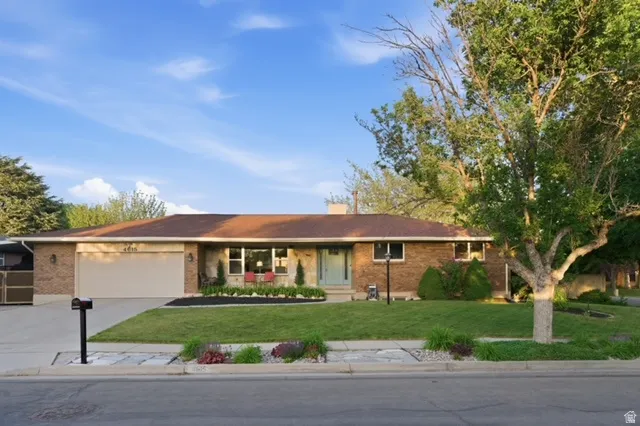 Brick exterior with a light brown roof and an attached garage