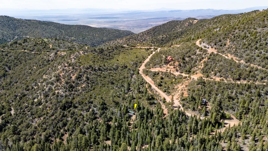 Expansive mountain landscape featuring dense evergreen forestry and natural terrain