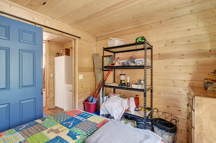 Wood-paneled room featuring a blue barn door on a black track system