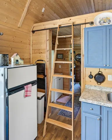 A light wood-finish ladder provides vertical access within this space, featuring wood paneling on walls and ceiling