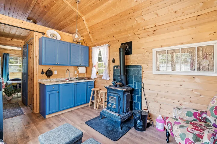 Open-concept living space with wood-finish flooring and wood plank walls