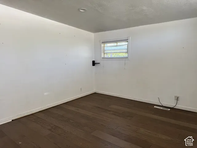 Interior room featuring wood-finish flooring, white painted walls, and white baseboards