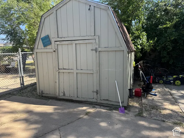 Wood-sided storage shed with a gambrel roof and double barn doors