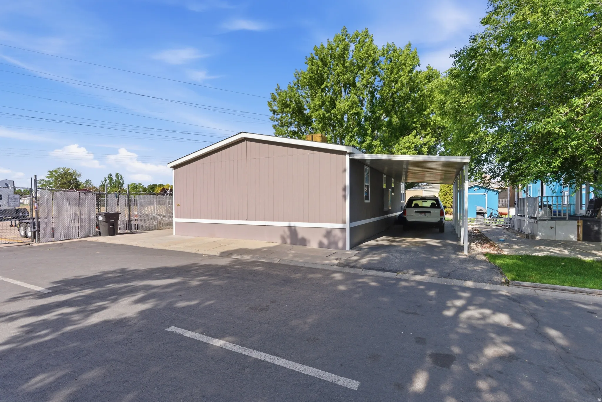 Exterior featuring a covered carport, neutral-toned siding, and a fenced perimeter