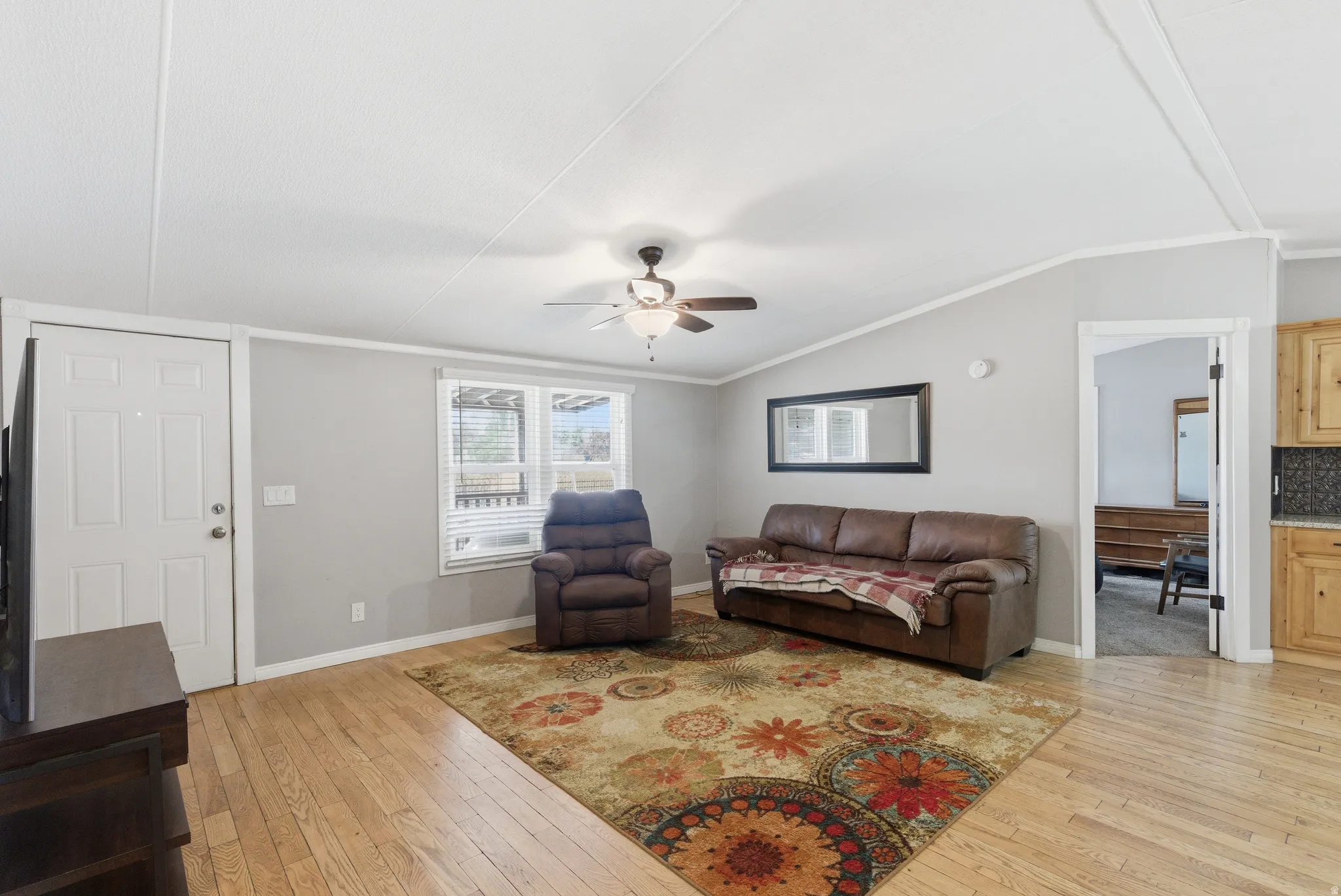 Open concept living area featuring wood-finish flooring, light gray wall paint, and a ceiling fan