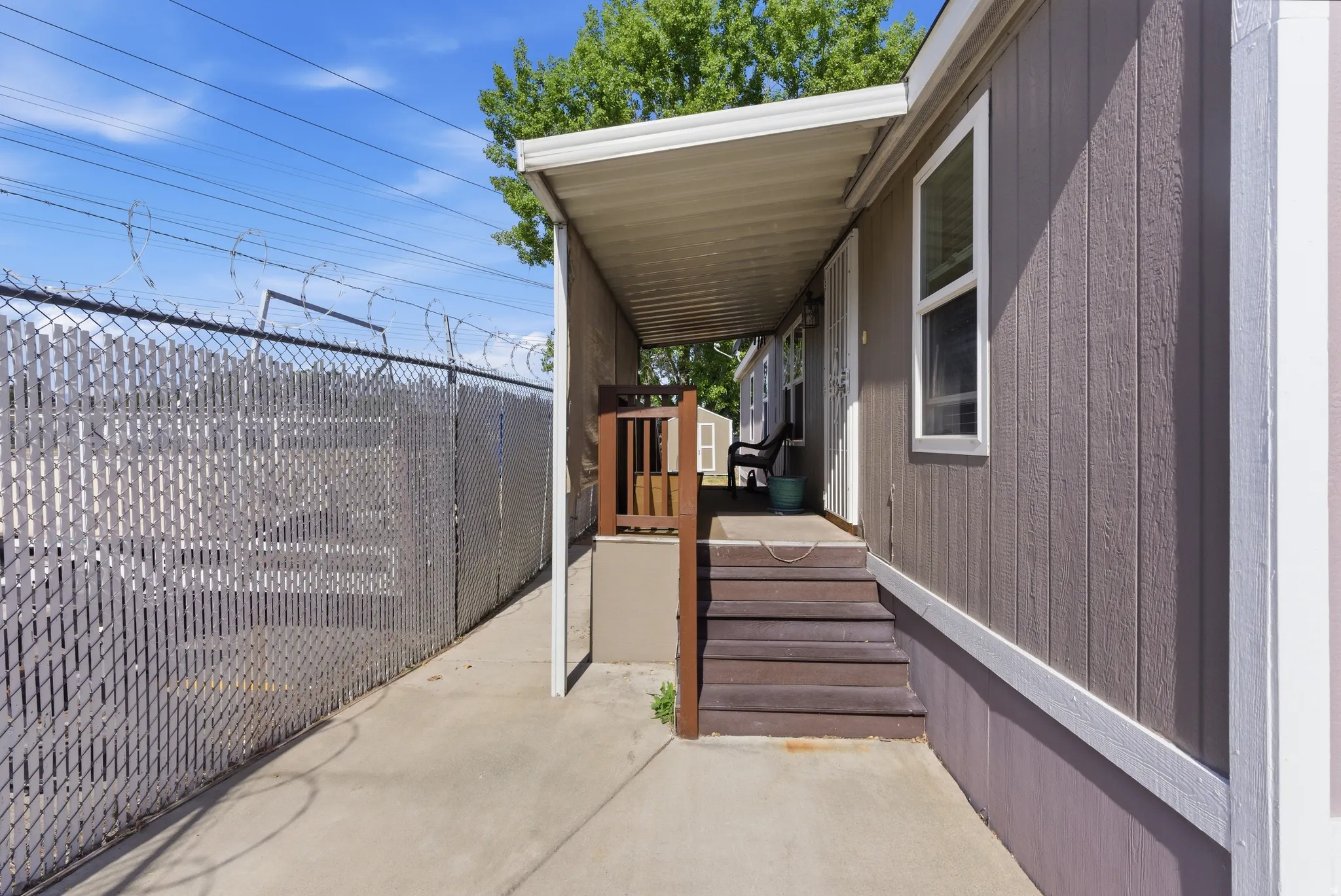 Covered entryway with wood-finish steps and vertical siding