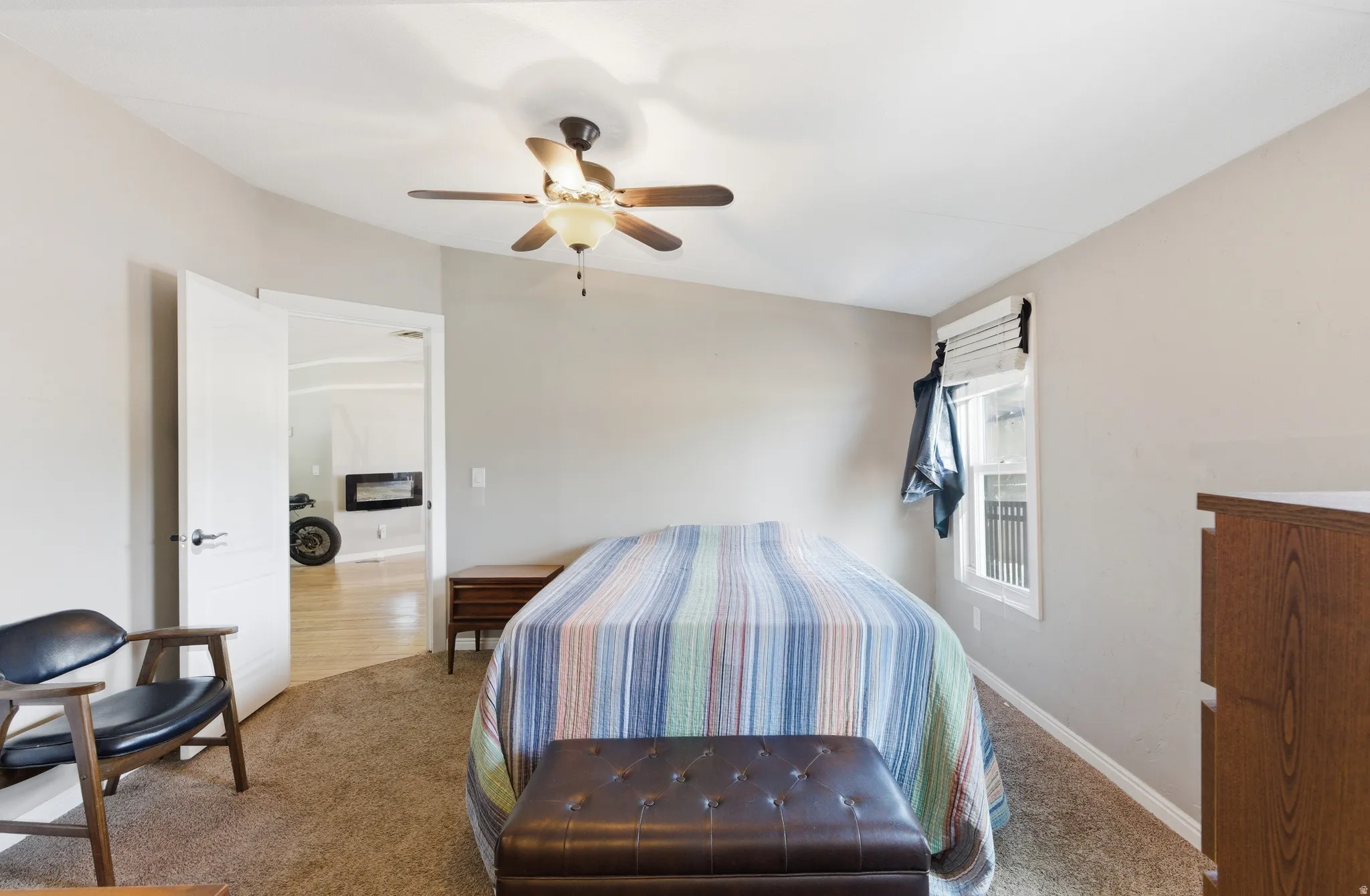 Carpeted room with a ceiling fan light fixture