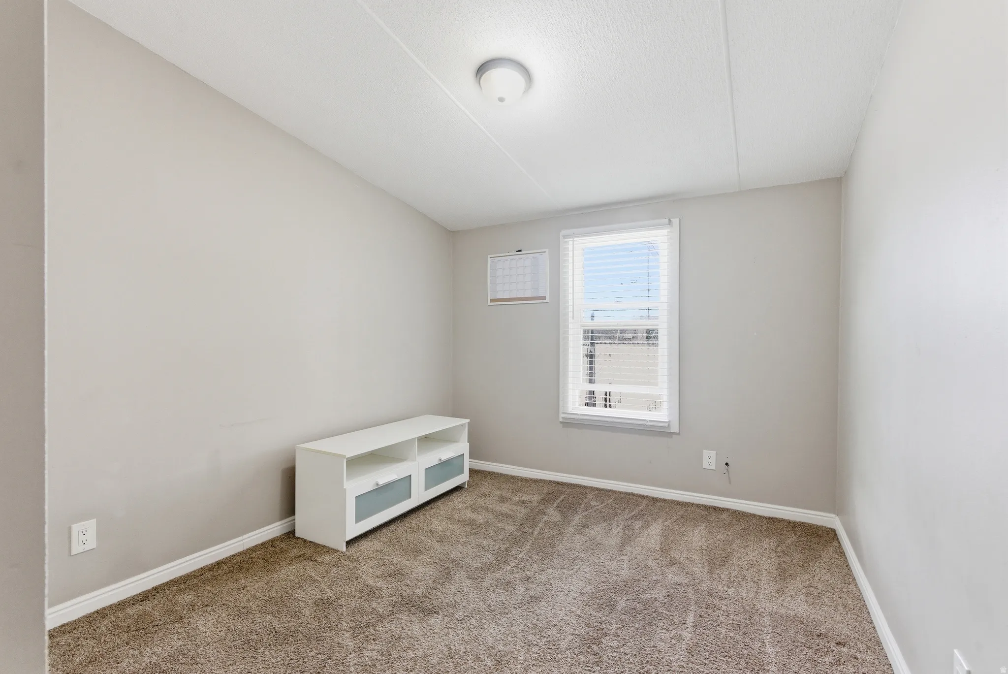 Neutral-toned walls complement the textured carpeting