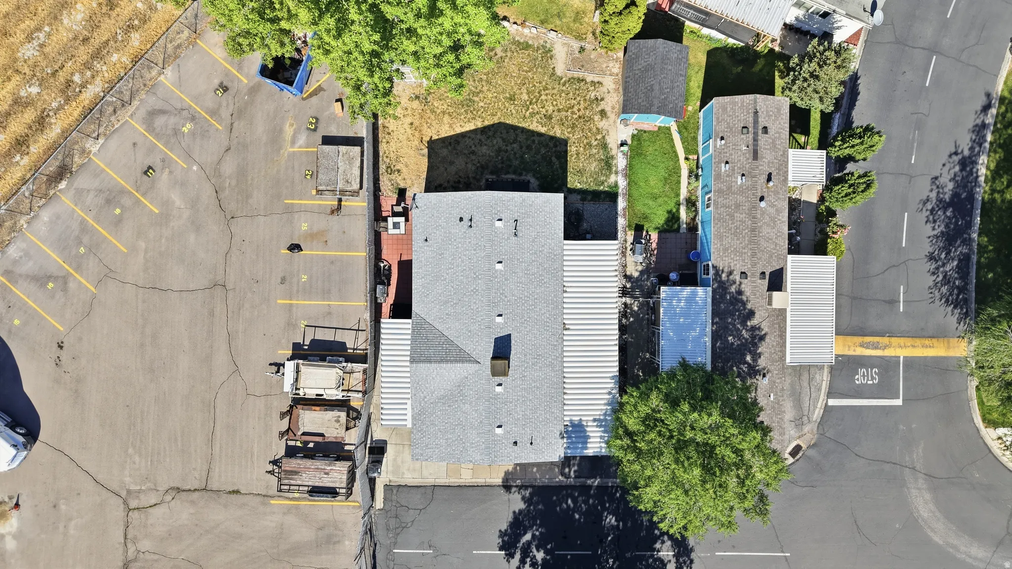 Paved parking lot with designated spaces, adjacent to an asphalt surface street