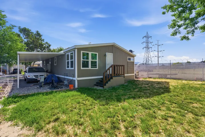 Single-story residence featuring a covered carport, wood-finish exterior siding, and a rear deck with wood railings